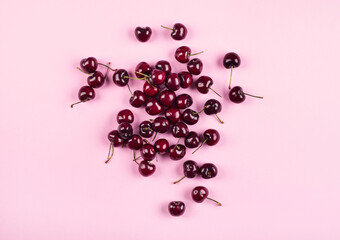 Heap of cherries on pink background. Summer berries
