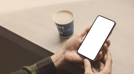 cell phone mockup image blank white screen.woman hand holding texting using mobile on desk at coffee shop.background empty space for advertise.work people contact marketing business,technology