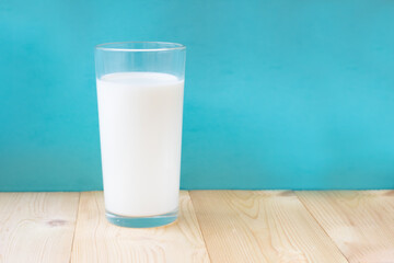 Glass of fresh milk on blue background.Single object
