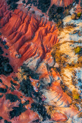 Gant, Hungary - Aerial horizontal drone view of abandoned bauxite mine with warm red and orange colors at sunset. Red bauxite texture