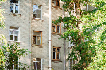 Fototapeta na wymiar Fragment of a 5-storey residential brick house. Typical residential development, Russia.