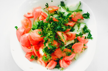 A fresh vegetable salad. Cucumbers, tomatoes and herbs.