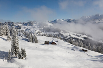 Fototapeta na wymiar Winter landscape with fog towards Ibergeregg in central Switzerland