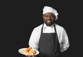 Male African-American chef with tasty dish on dark background