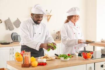 African-American chefs cooking in kitchen