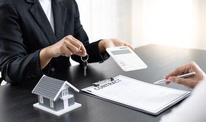 Female salesman is negotiating a home transaction with a male client in the office.
