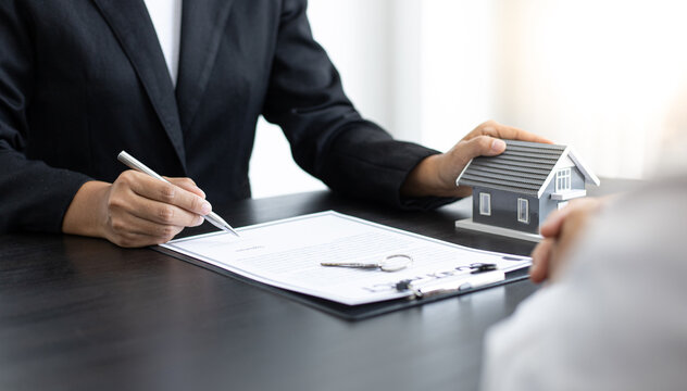 saleswoman gave the keys and house to the customer who signed the purchase contract.