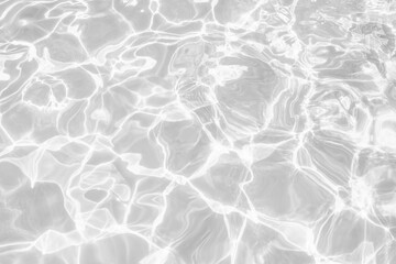 Closeup of desaturated transparent clear calm water surface texture with splashes and bubbles. Trendy abstract nature background. White-grey water waves in sunlight