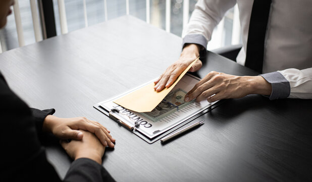 Asian man gave a bribe to a female employee in the office.