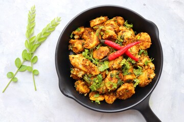 Stir fried taro roots. Arbi ki sabji, Taro roots masala curry. Arbi Masala. Garnished with coriander, red chili & curry leaves. copy space.