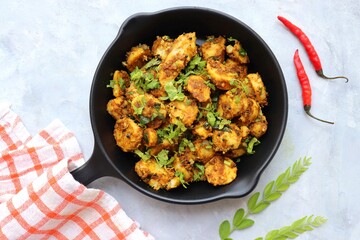Stir fried taro roots. Arbi ki sabji, Taro roots masala curry. Arbi Masala. Garnished with coriander, red chili & curry leaves. copy space.
