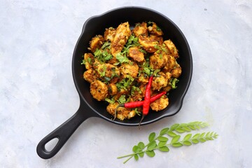 Stir fried taro roots. Arbi ki sabji, Taro roots masala curry. Arbi Masala. Garnished with coriander, red chili & curry leaves. copy space.