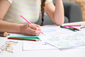 Young woman coloring picture at home, closeup
