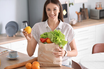 Young woman with fresh products from market at home