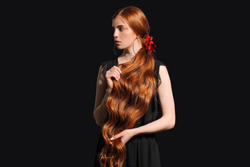 Fototapeta premium Beautiful young redhead woman on dark background