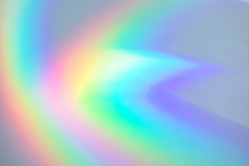 Blurred rainbow light refraction texture overlay effect for photo and mockups. Organic drop diagonal holographic flare on a white wall. Shadows for natural light effects