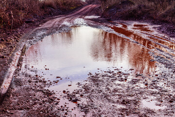 Red dirt road polluted with the iron ore. Environmental pollution