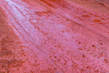 Background of red dirt road polluted with the iron ore. Environmental pollution