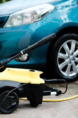 Car wash at home alone. Car wash high pressure close-up. A man washes a green car.