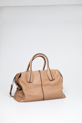 brown leather bag on white