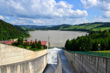 Water overflow in the dam. Opened water dam. Dam and water reservoir in Niedzica was created in order to reduce flood culminations.  Czorsztyn lake, southern Poland, Europe. 