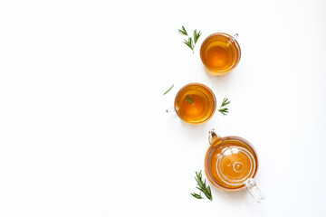 Herbal tea with rosemary in a glass teapot on a white background. .