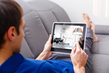 Creative businessman writing on graphic tablet while using laptop in office