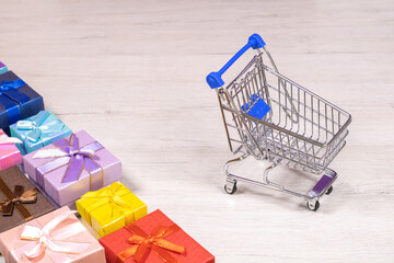 Shopping carts with gifts inside on a background of bleached wood.