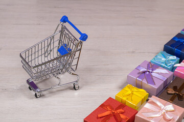 Shopping carts with gifts inside on a background of bleached wood.