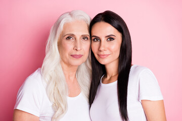 Photo of cute old mother young pretty daughter two ladies good mood stand close best friends through years wear casual white t-shirts isolated pastel pink color background