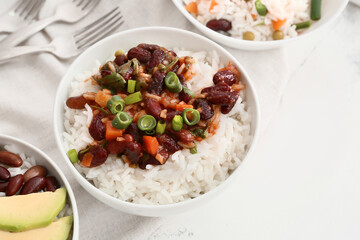 Bowl with tasty rice, beans and vegetables on table