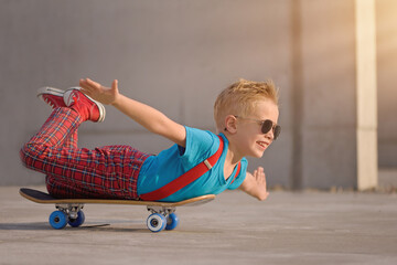 Boy skateboarding on street, lying on belly 