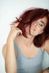 Naklejka premium Beautiful young ginger woman. Portrait of charming girl wearing casual clothes posing at home