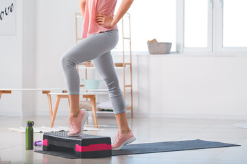 Sporty young woman training at home