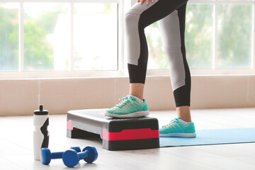 Sporty young woman training at home
