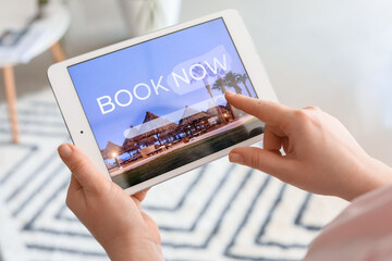 Woman with tablet computer booking tickets online at home