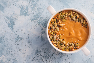 Pot of tasty lentils soup on color background