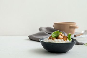 Bowl with boiled rice and chicken on table