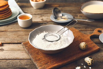 Bowl with flour for pancakes on table