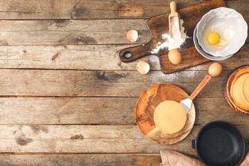 Tasty pancakes with ingredients on wooden background