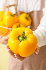 Woman with yellow bell pepper, closeup