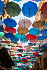 Fototapeta na wymiar Colorful umbrellas - decoration on streets in Catania city center, Sicily, Italy