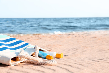 Bag with sunscreen cream on beach