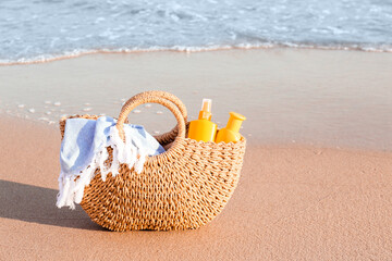 Bag with sunscreen cream on beach