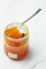 jar with apricot jam on a white background close-up.