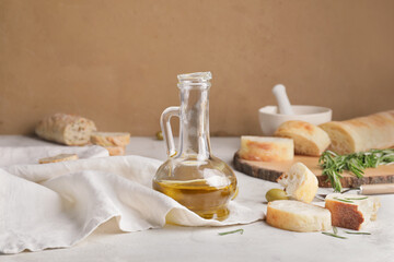 Fototapeta na wymiar Bottle of tasty olive oil and bread on table