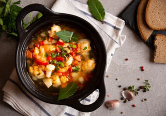 Vegetable soup with cauliflower, laurel and other vegetables in cooking pot