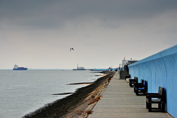 Obraz premium Benches by the sea wall at Concord beach Canvey Island, Essex, England