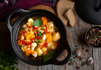 Vegetable soup with cauliflower, laurel and other vegetables in cooking pot