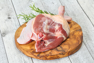 Raw duck leg served rosemary